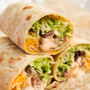 Three Big Mac Wraps stacked on parchment paper