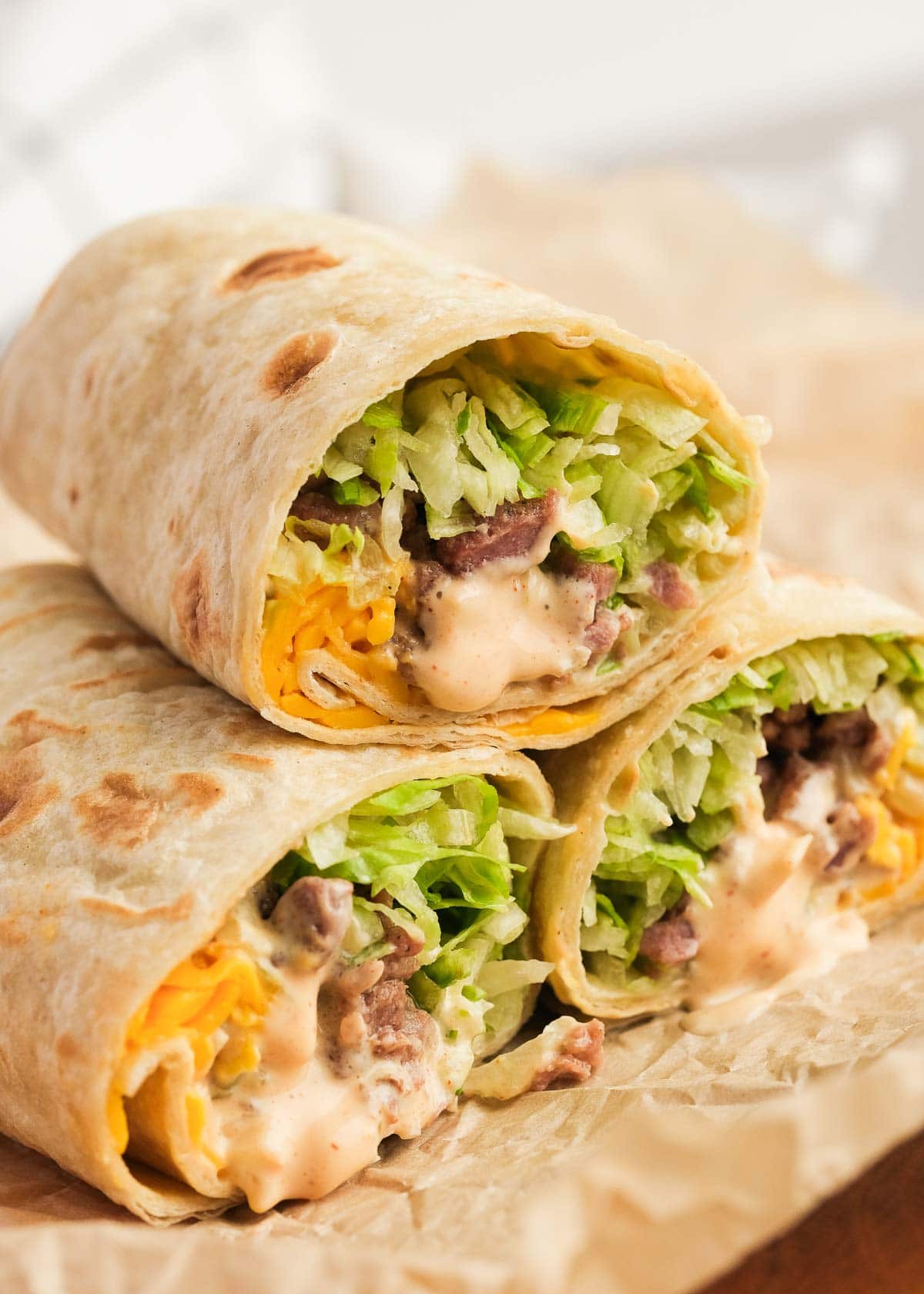 Three Big Mac Wraps stacked on parchment paper