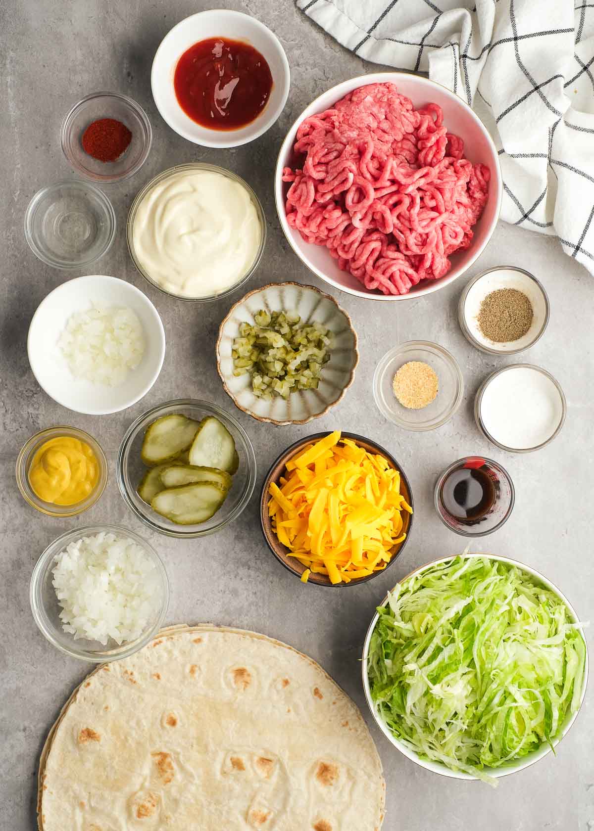 all ingredients needed for big mac wraps on a countertop in individual bowls