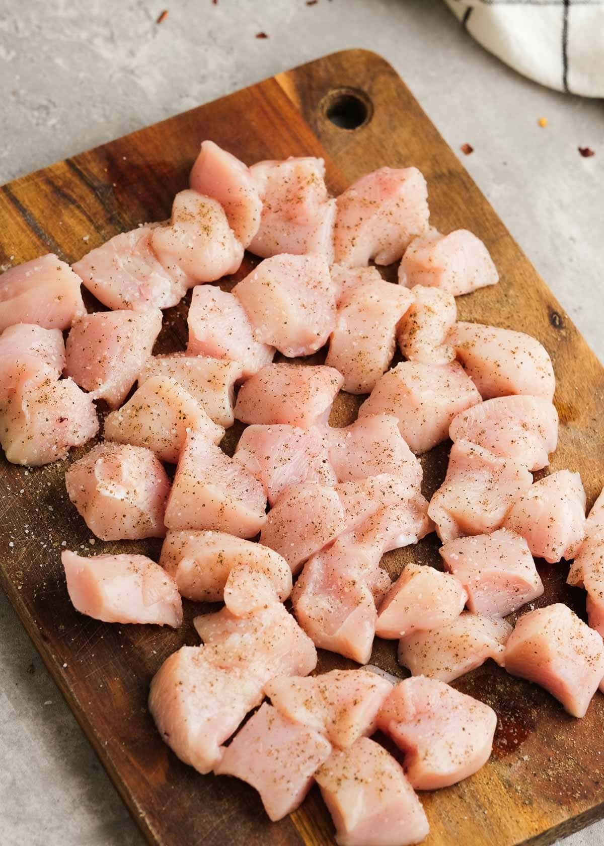 cubed chicken breast on a cutting board