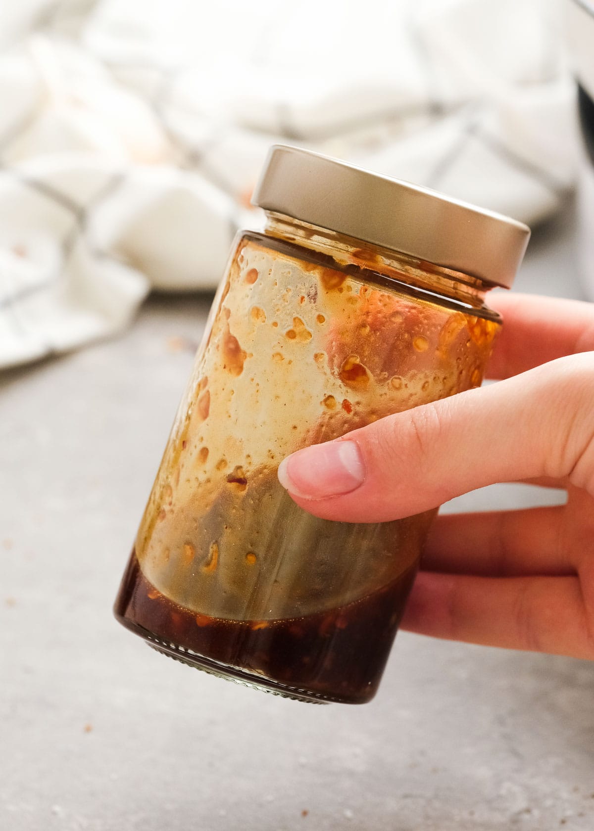 soy sauce, sesame oil, brown sugar, garlic, rice vinegar, and chili garlic sauce in a jar