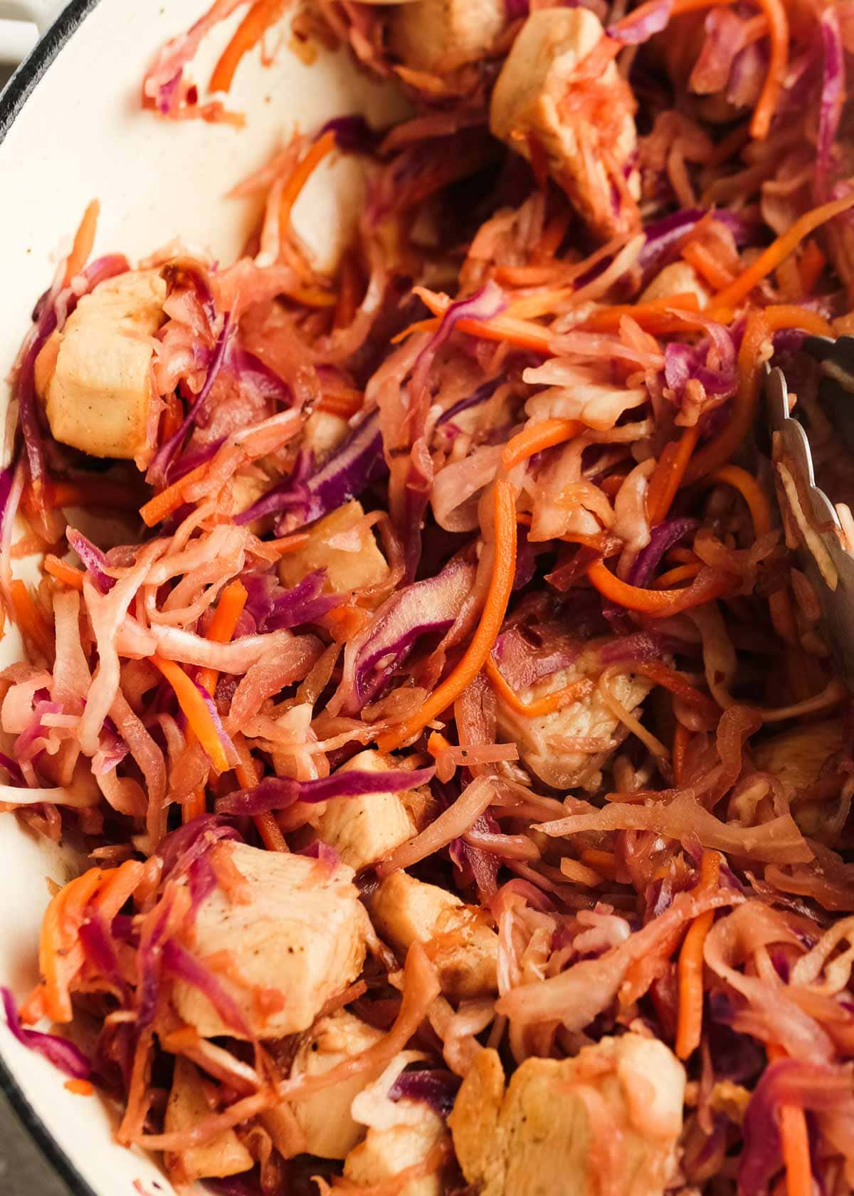 yummy shredded cabbage and carrots mixed with cooked chicken pieces and covered in sesame sauce