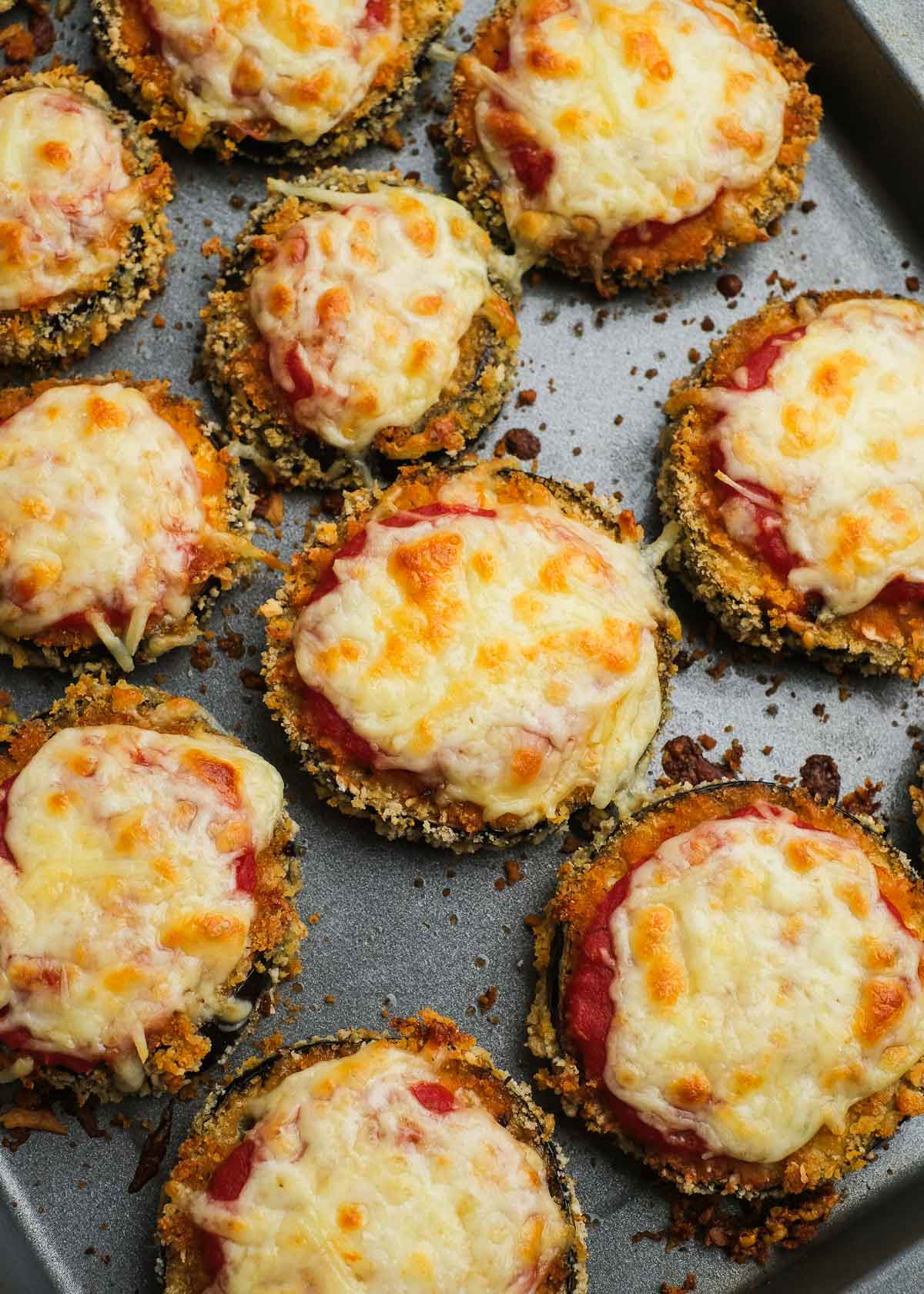 single breaded eggplant bites topped with marinara and mozzarella, baked until golden brown on a baking pan