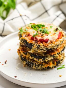 three eggplant parmesan bites stacked for a delicious vegetarian dinner on a white plate