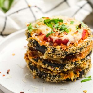 three eggplant parmesan bites stacked for a delicious vegetarian dinner on a white plate