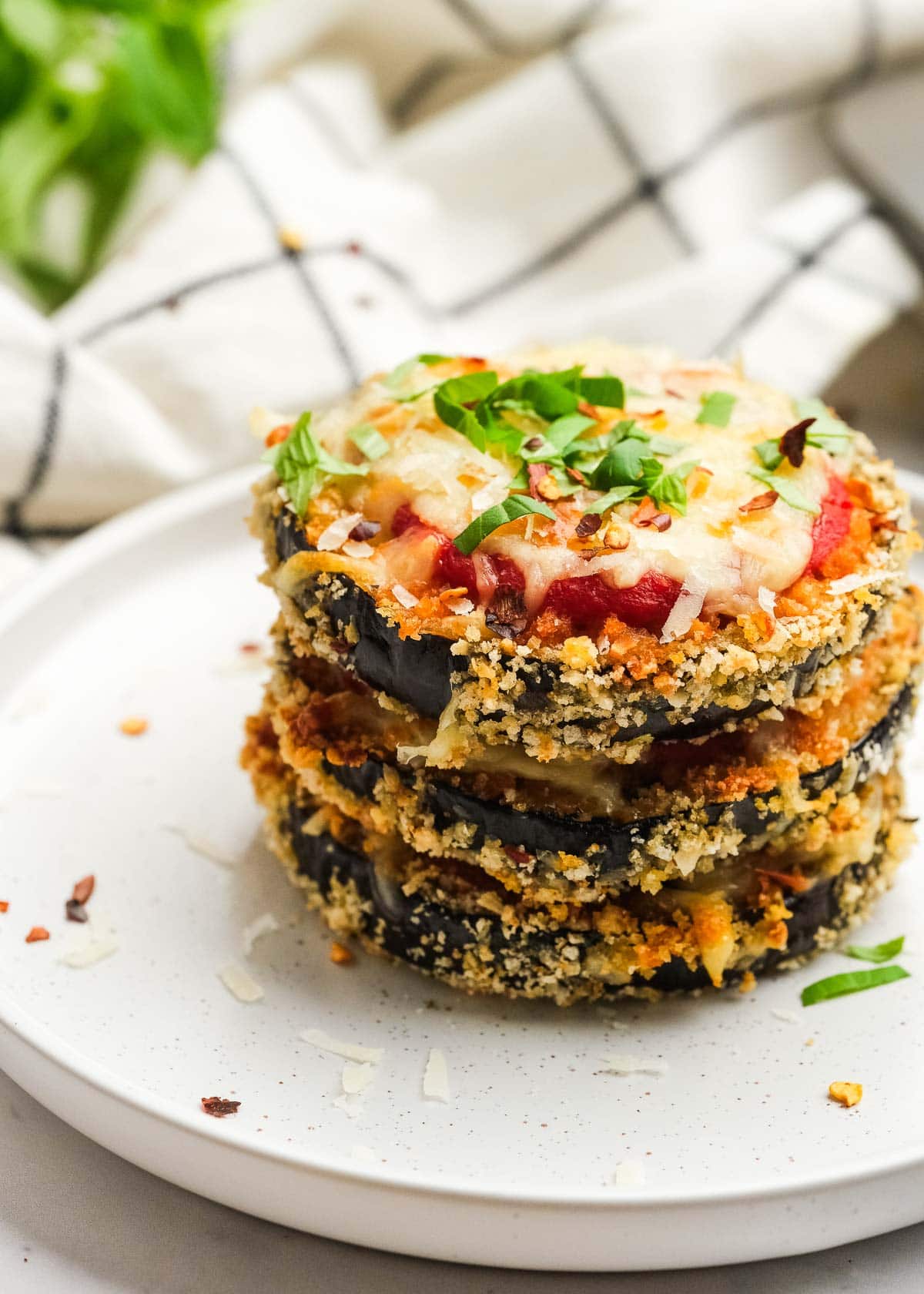 three eggplant parmesan bites stacked for a delicious vegetarian dinner on a white plate