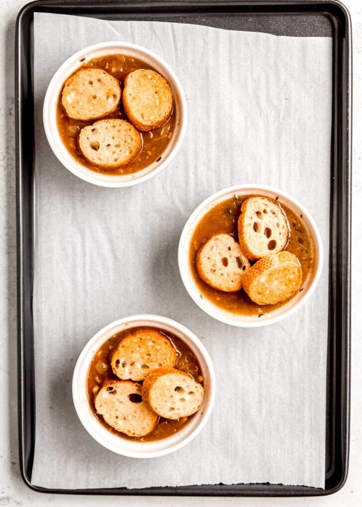 french onion chicken soup topped with toasted baguette slices