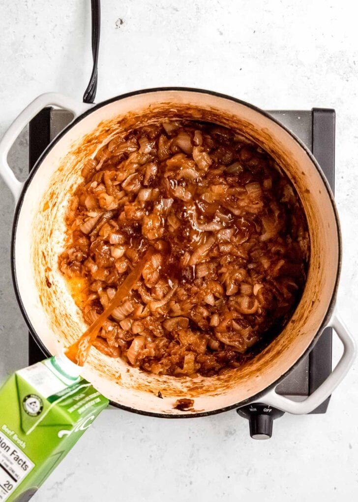 broth being added to caramelized onions