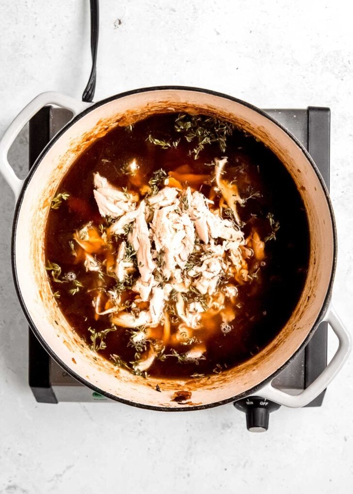 chicken, broth, worcestershire sauce, wine, and thyme added to the pot of caramelized onions to make french onion chicken soup