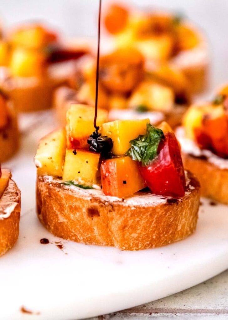 sweet balsamic reduction drizzled over a peach and tomato bruschetta