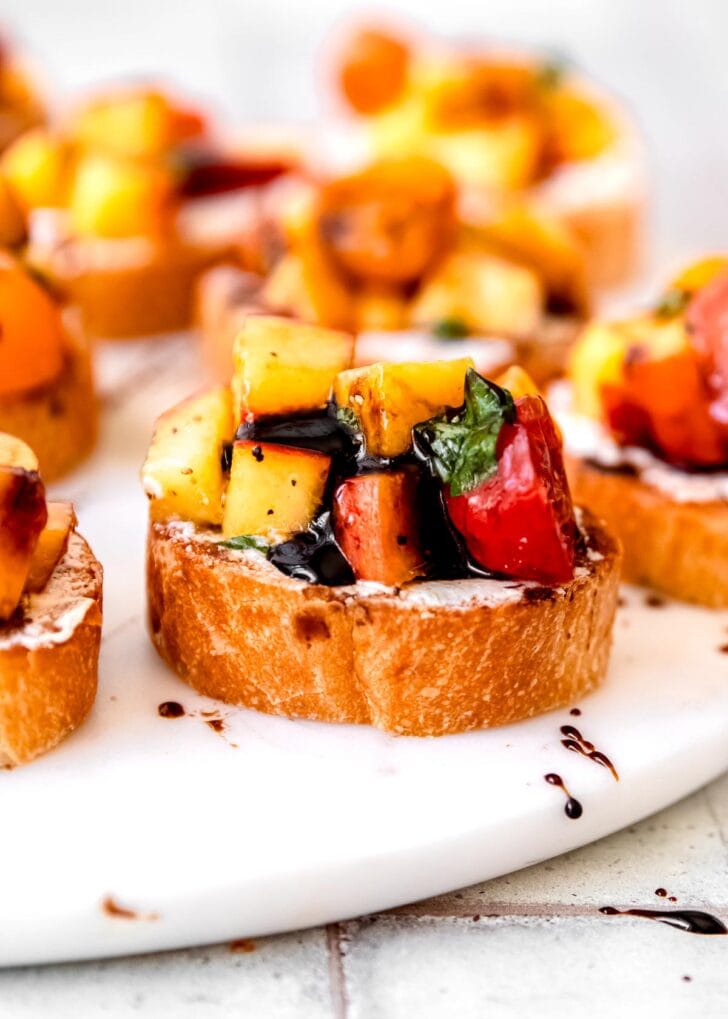 toasted baguette slices covered with goat cheese, peach tomato mixture, and balsamic reduction