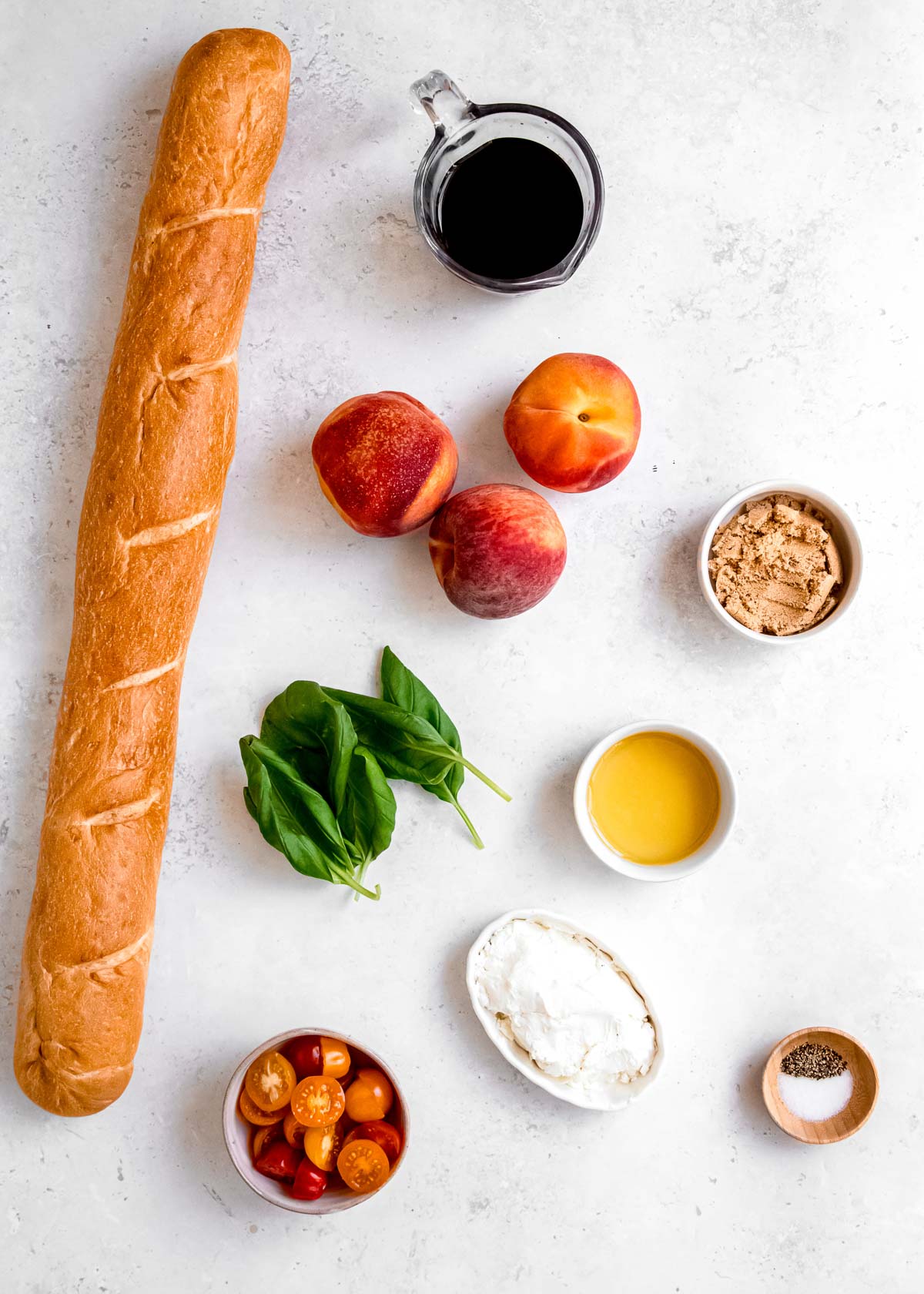 all ingredients needed for peach bruschetta in individual bowls on a white background