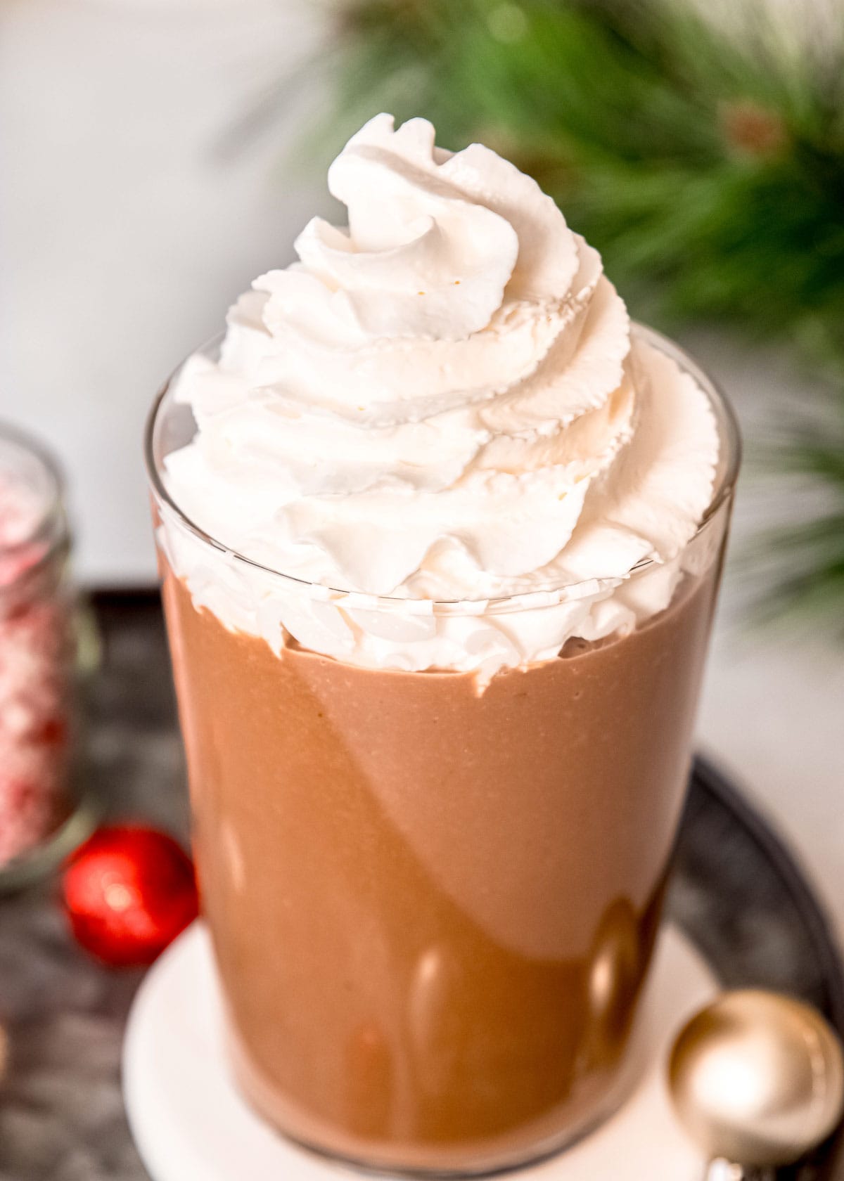 overhead shot showing a keto protein shake with peppermint mocha flavor, topped with sugar-free whipped cream