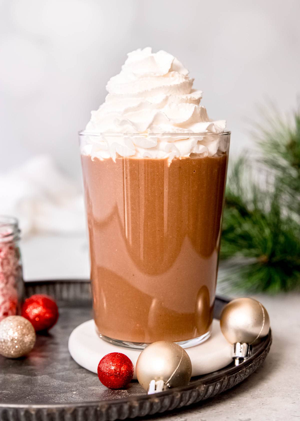 a tall mound of keto whipped cream atop of creamy peppermint mocha protein shake