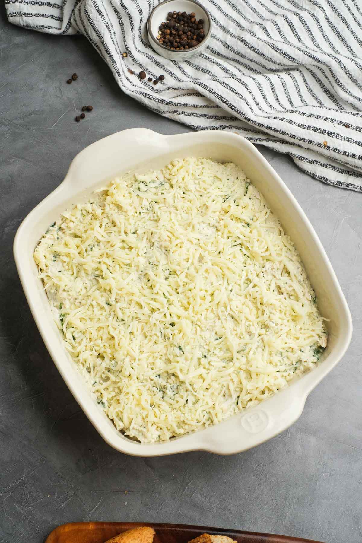 creamy chicken dip topped with shredded mozzarella before baking