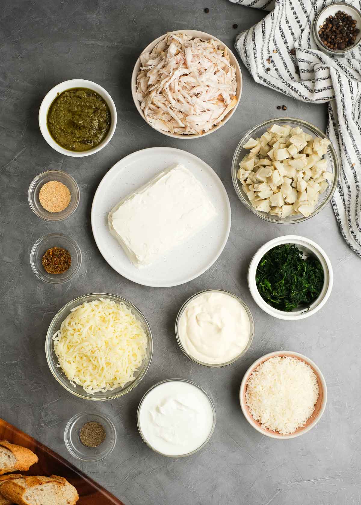 All ingredients needed for creamy pesto chicken dip on a gray countertop