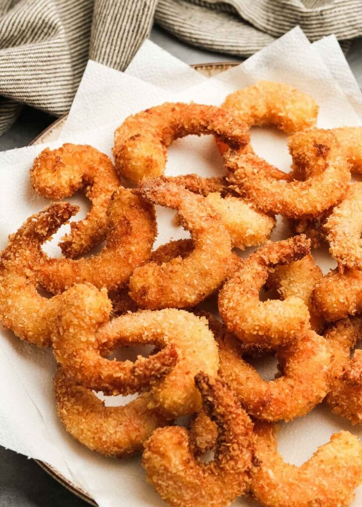 fried popcorn shrimp on a paper towel lined plate