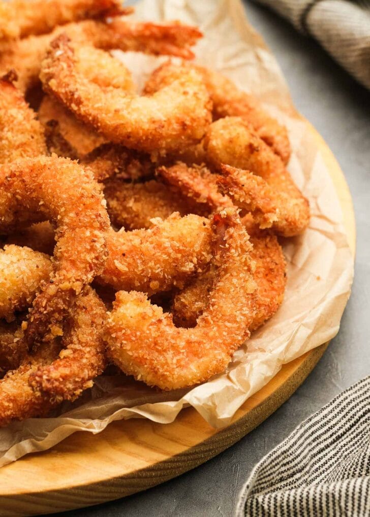 a parchment paper lined platter filled with gluten-free popcorn shrimp