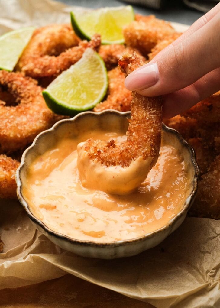 easy popcorn shrimp being dipped into a simple, flavorful dipping sauce