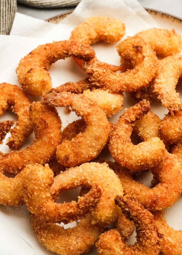 juicy, crunchy popcorn shrimp on a paper towel lined plate