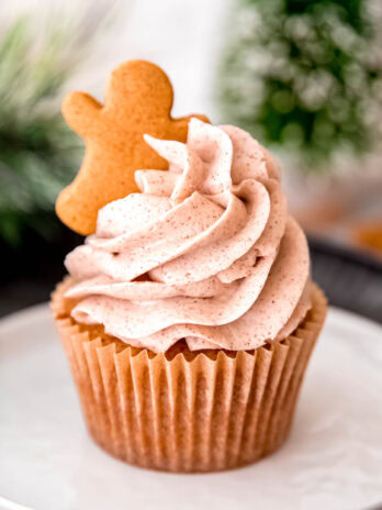 a gorgeous gluten-free gingerbread cupcake topped with perfectly piped cinnamon buttercream frosting and garnished with a gingerbread man cookie