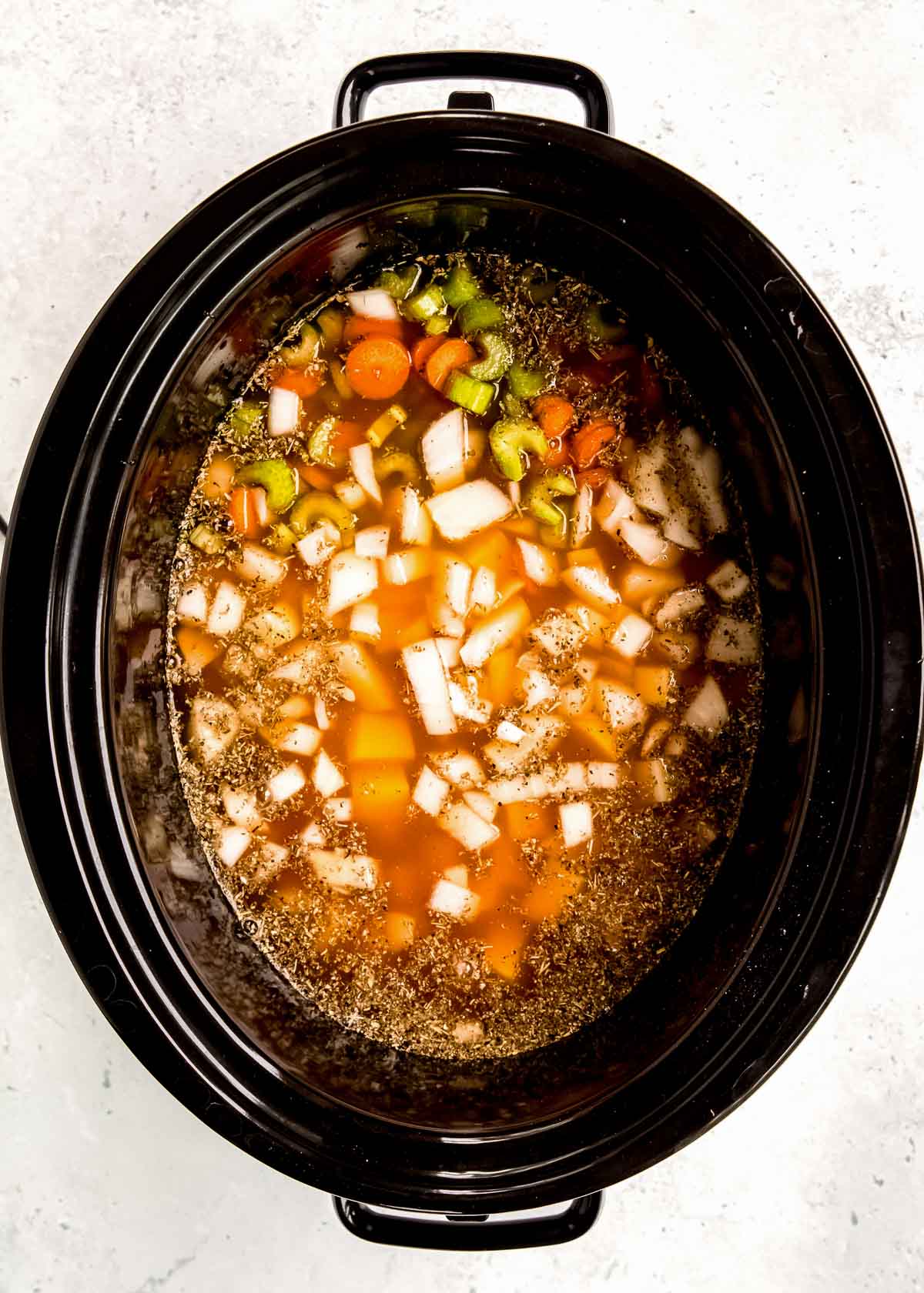 vegetables and broth in the slow cooker for potato soup