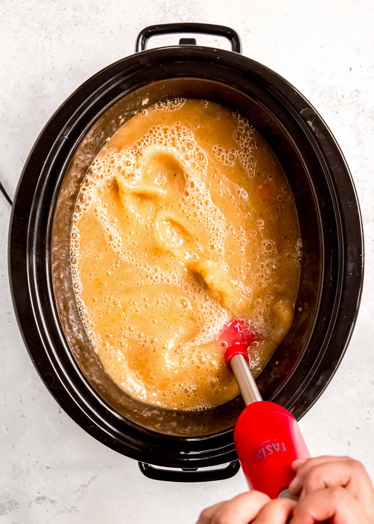 potato soup being blended in a slow cooker