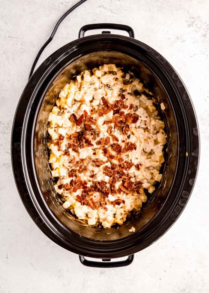 bacon on top of potatoes in a slow cooker