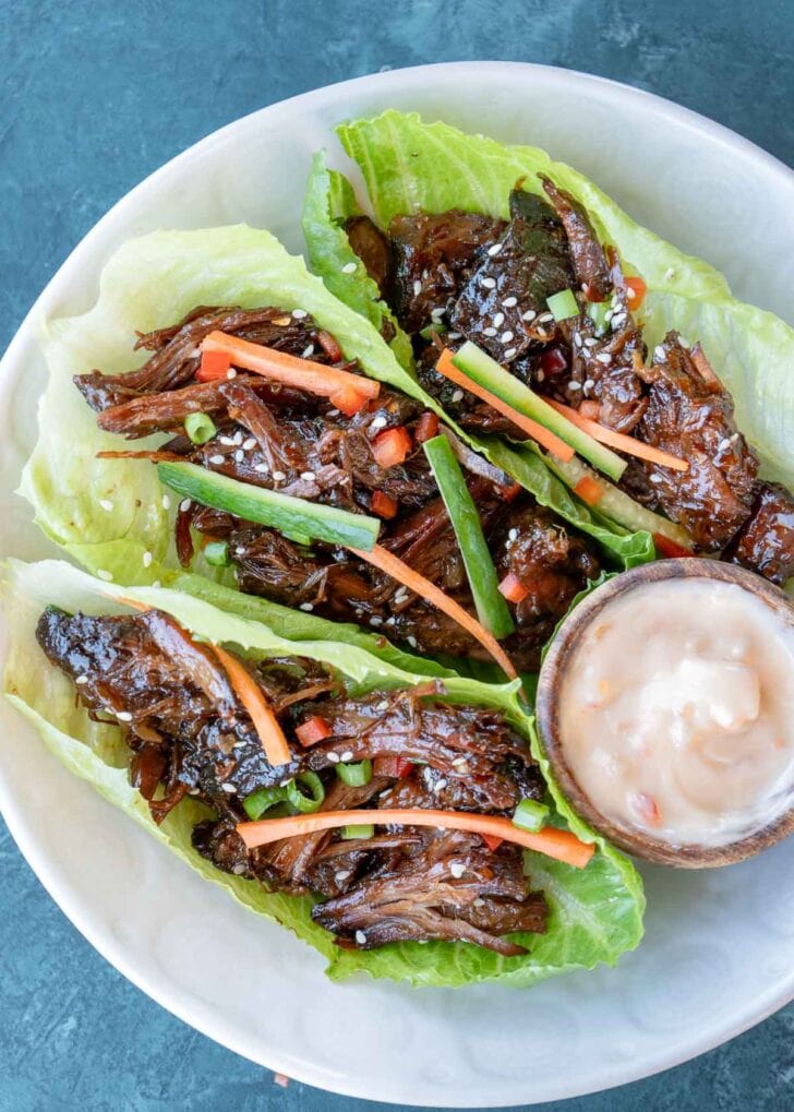 three lettuce wraps filled with sweet and spicy shredded beef