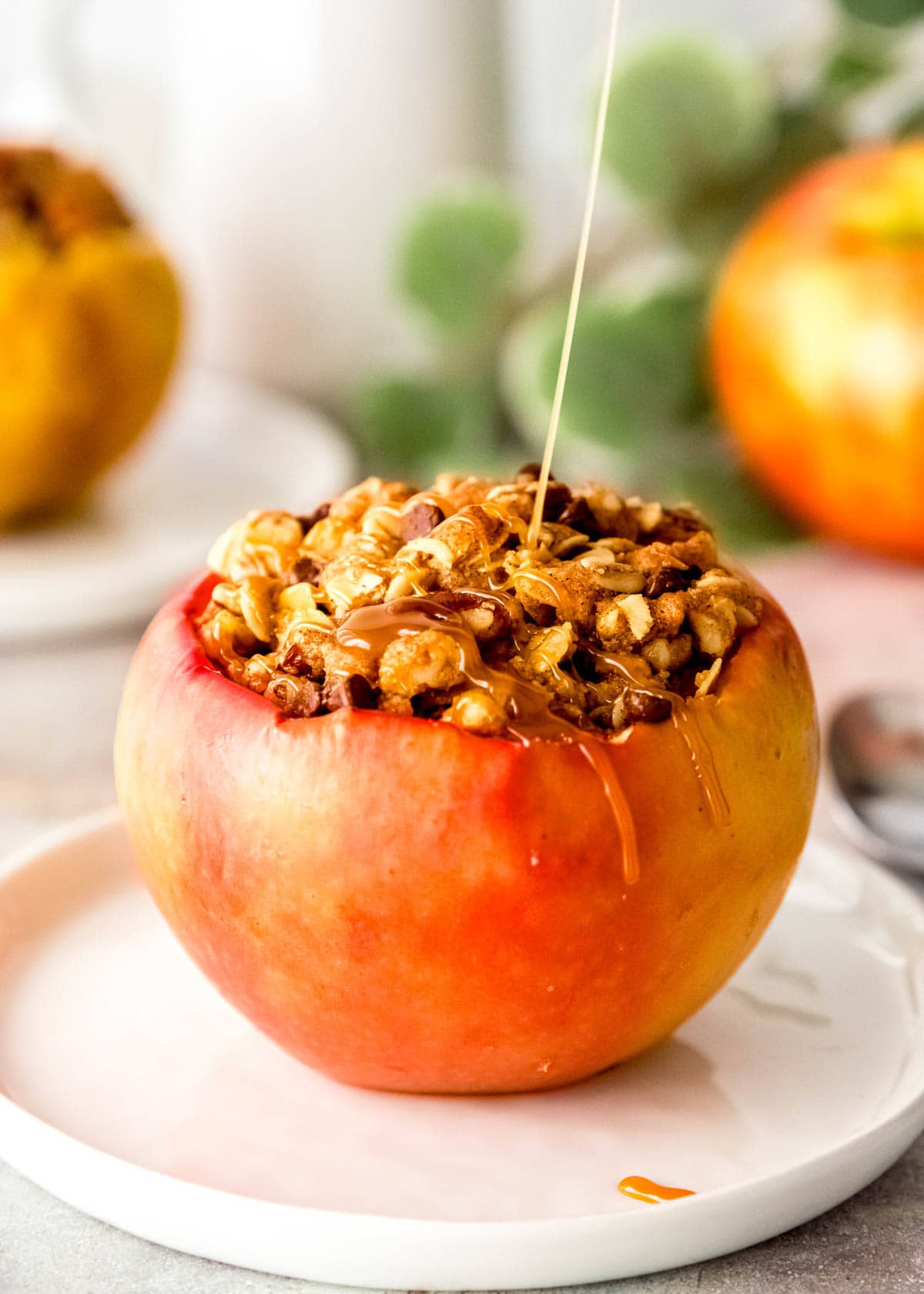 a close up shot of a stuffed baked apple with caramel drizzle