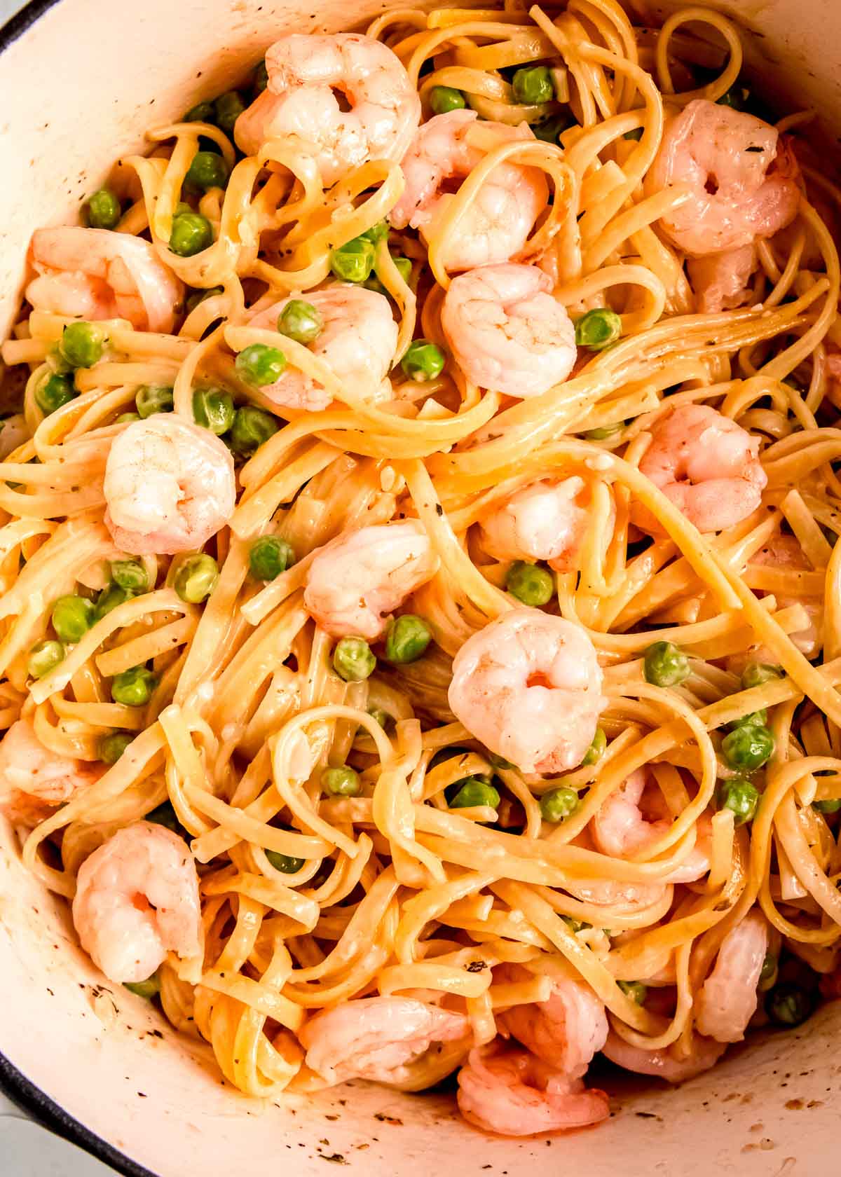 overhead shot of one pot shrimp pasta with a light, lemony creamy sauce with peas