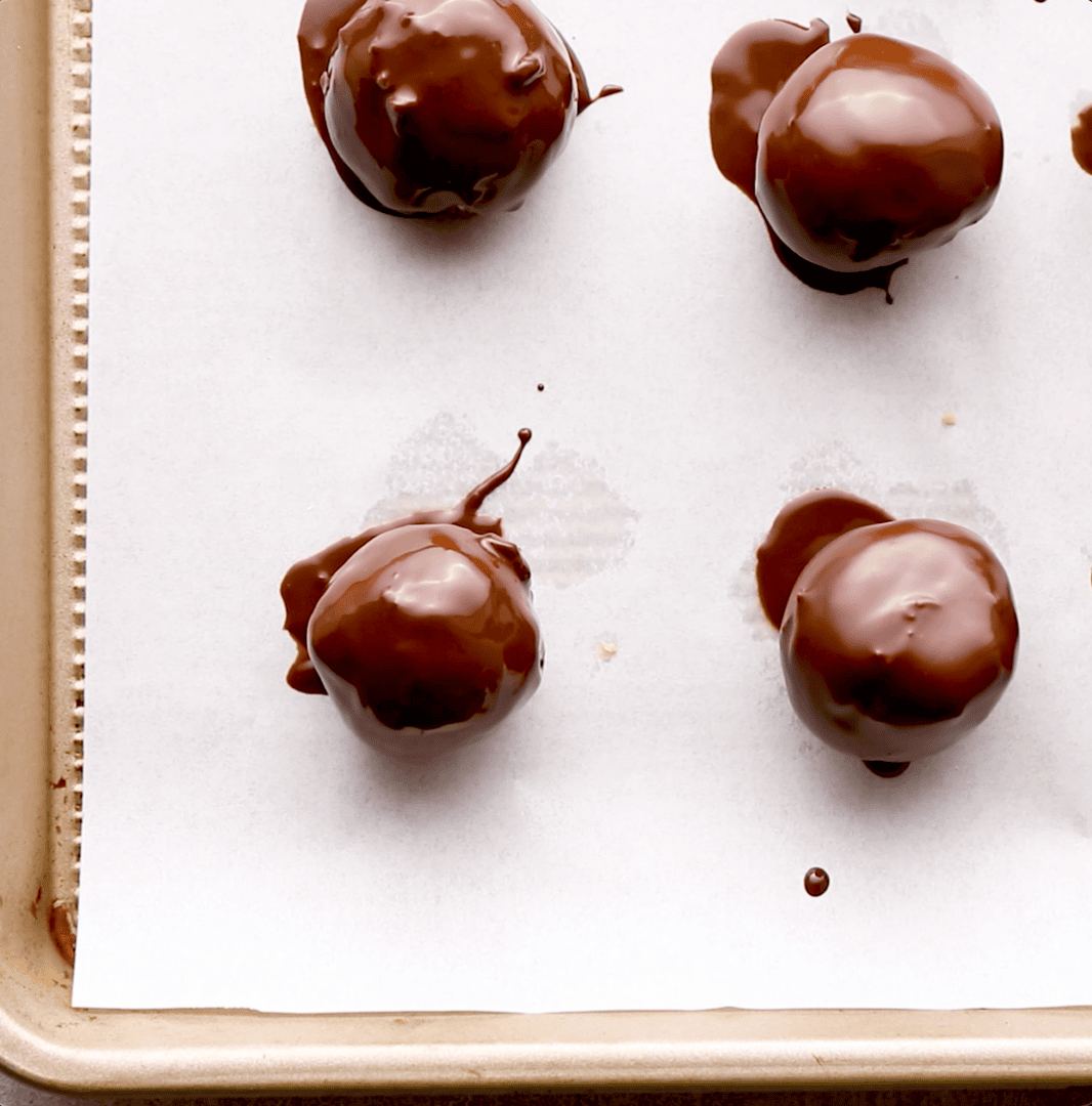 coated peanut butter cheesecake truffles on baking sheet