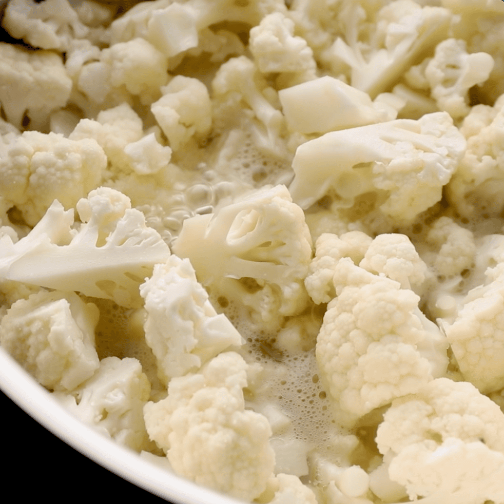 close up of cauliflower simmering in skillet