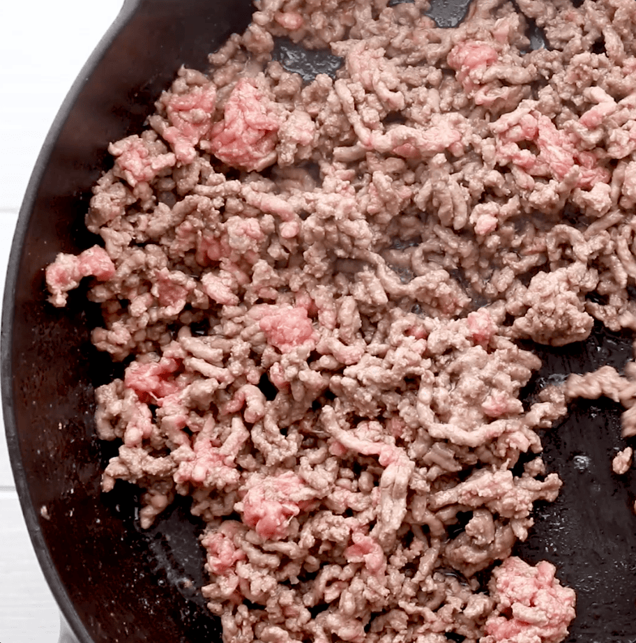 ground beef being browned in cast iron skillet