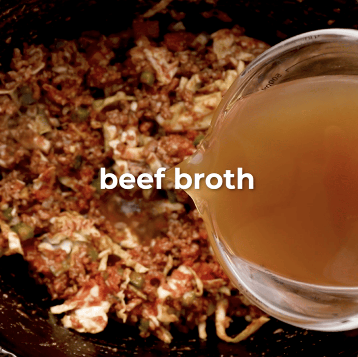 beef broth being added to cabbage roll soup in slow cooker