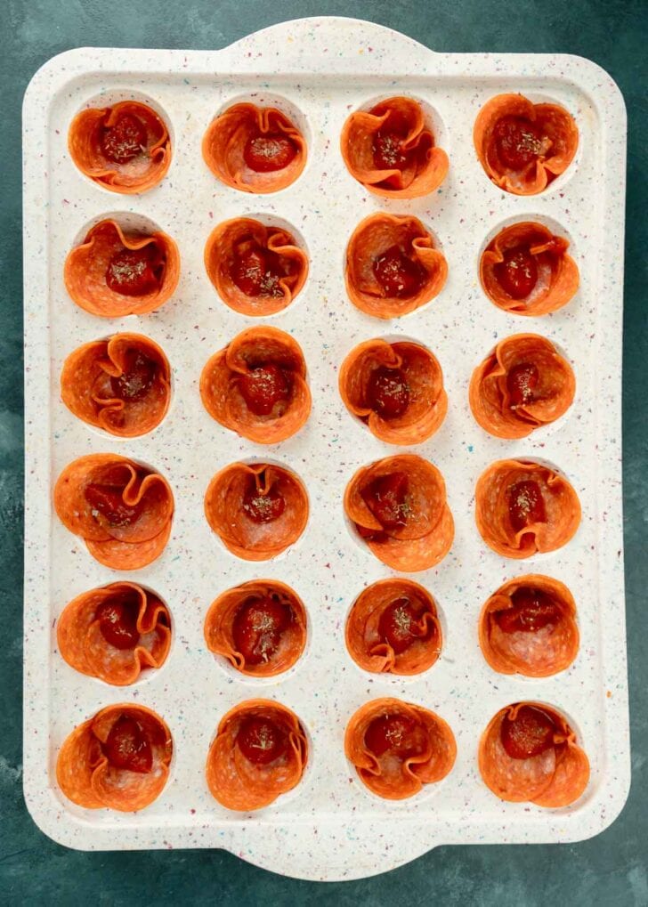 marinara sauce spooned into pepperoni cups