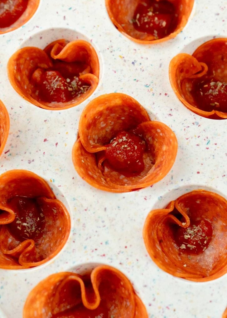 closeup view showing the teaspoon of marinara sitting in little pepperoni cups