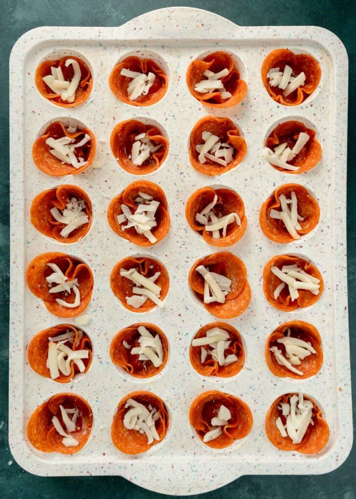 a pinch of shredded cheese added to each mini pizza snack