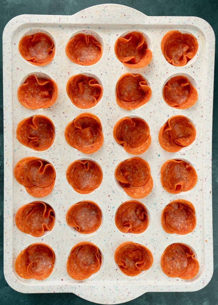 24 mini muffin wells filled with about 3 pepperoni each to make pepperoni cups