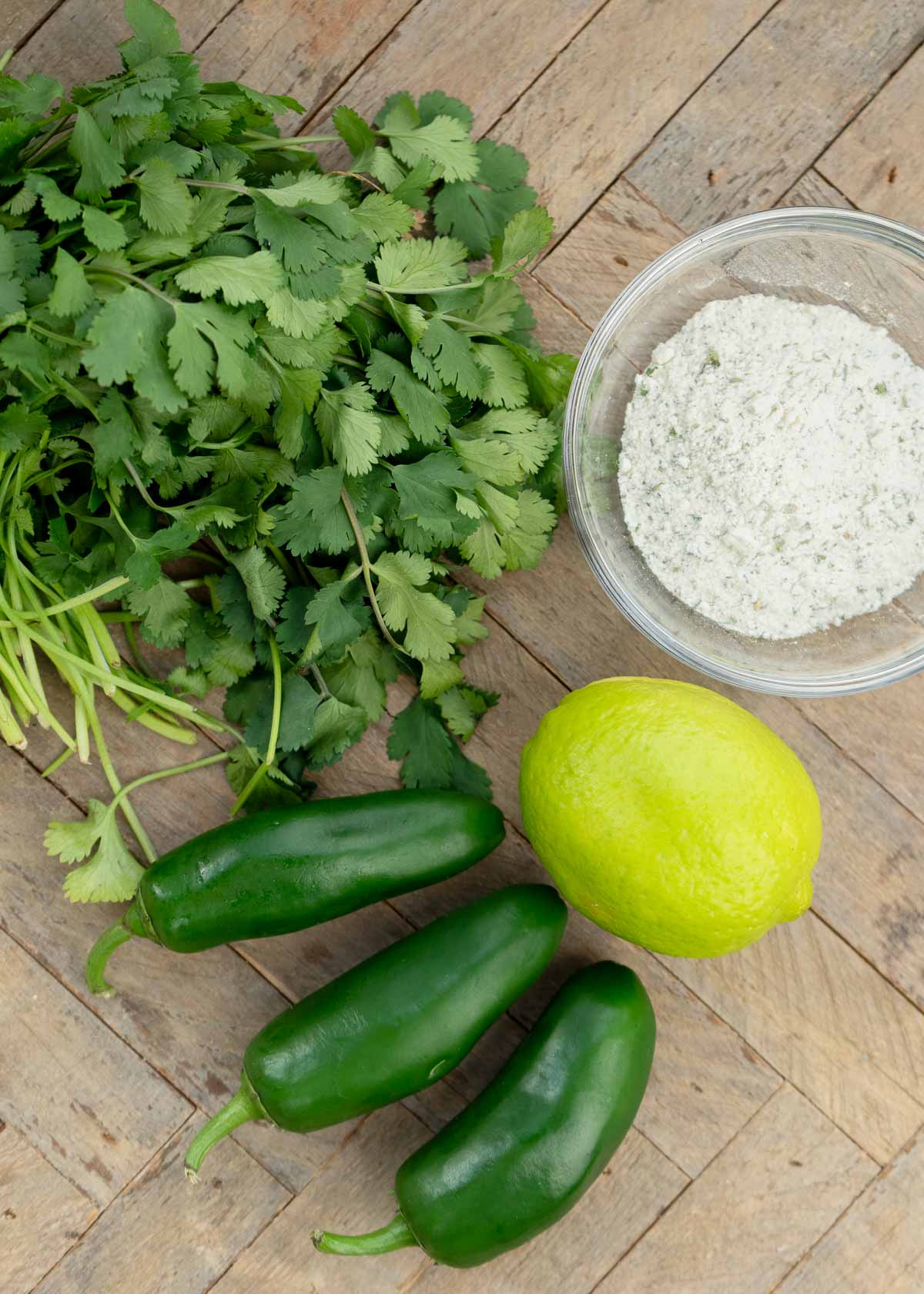 four ingredients needed for jalapeno ranch dip on a wooden countertop