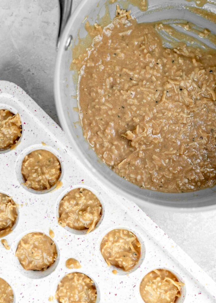 peanut butter coconut mixture spooned into a silicone muffin tin