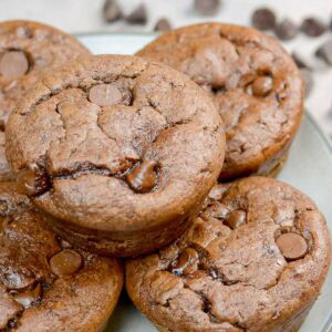 side angle showing fluffy gluten-free muffins on a plate packed with chocolate chips