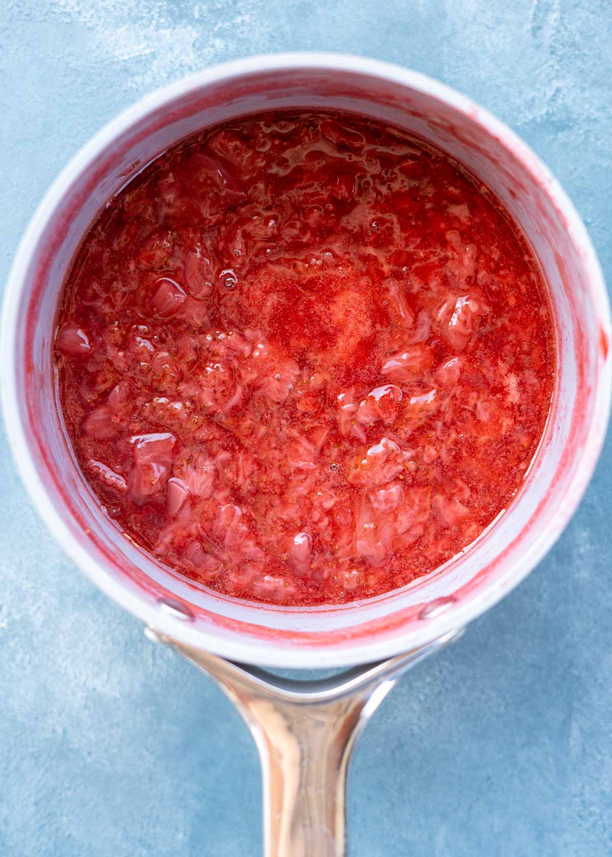 strawberries cooked down into a sauce in a saucepan